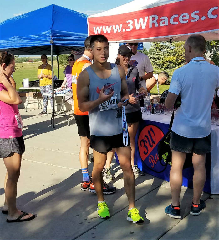 alex le picking up trophy longmont half marathon